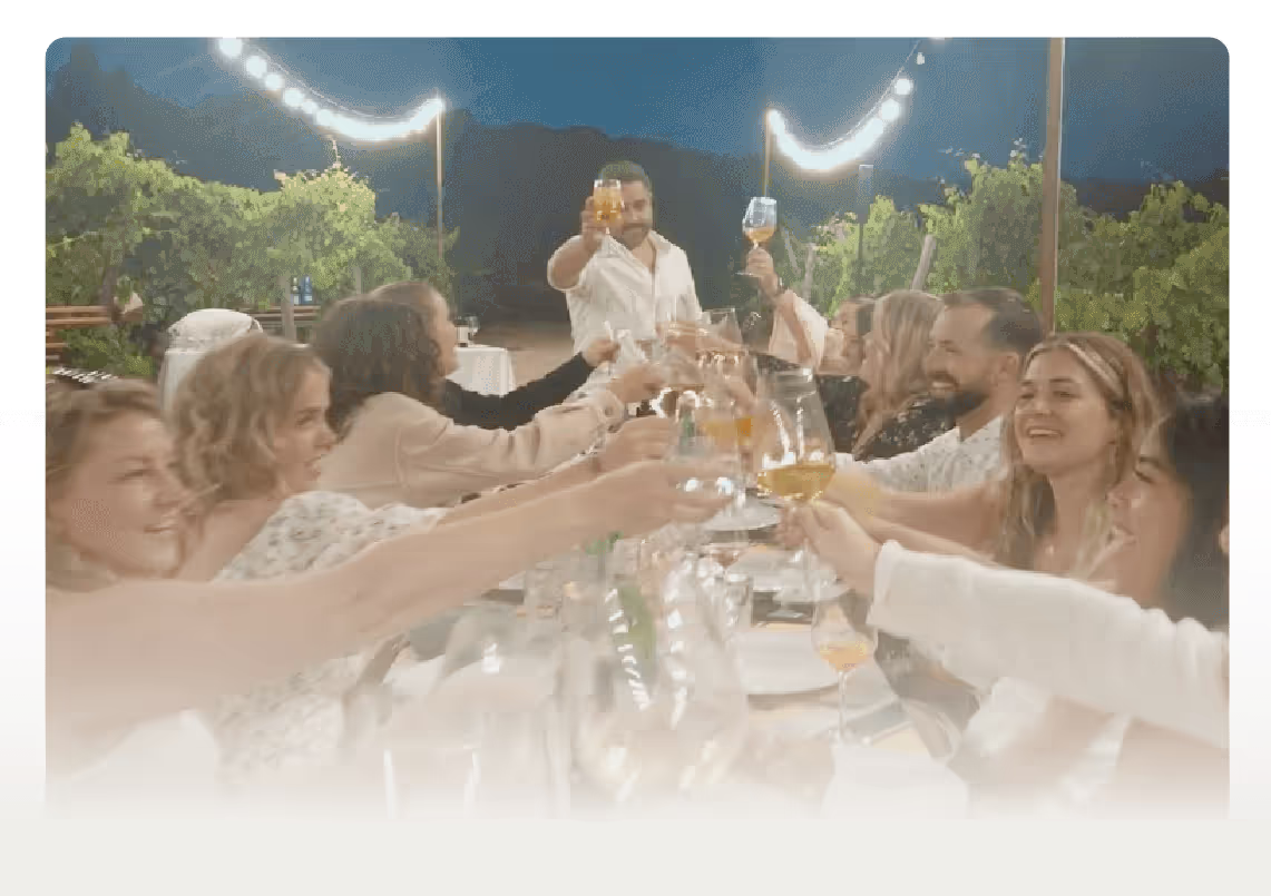 Wedding guests toasting and celebrating at an outdoor evening reception